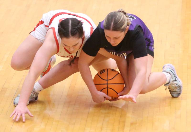 Dixon's Presley Lappin falls a loose ball against Ottawa's Mary Sisser on Wednesday, Dec. 3, 2025 in Kingman Gymnasium at Ottawa High School.