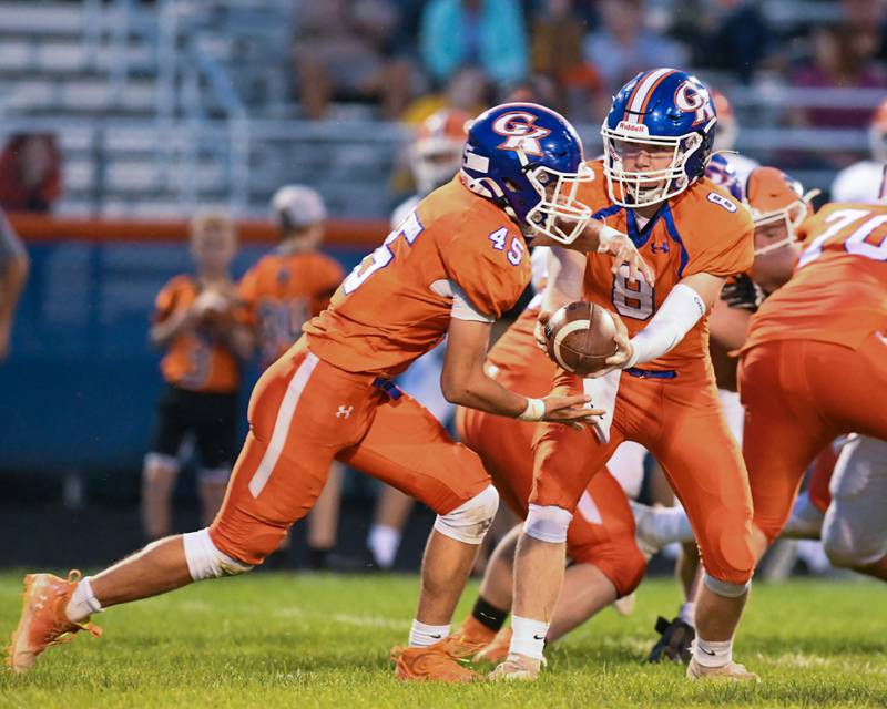Genoa-Kingston Nathan Kleba (8)  hands off the ball to teammate  Maddox Lavender (45) for a running play during the first quarter Friday Sep. 16th while taking on Byron at Genoa-Kingston