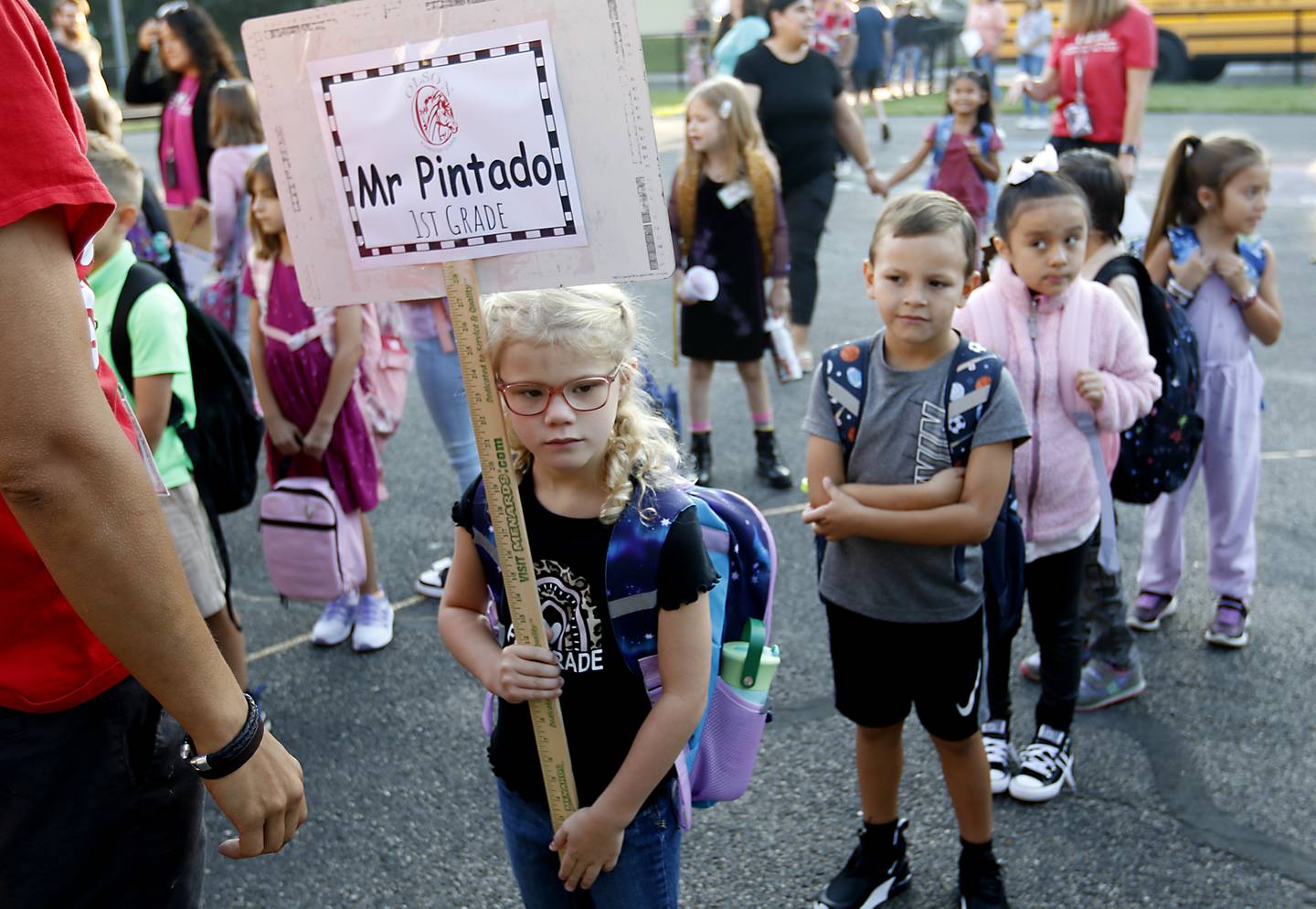 Olivia Goode holds the classroom sign as other students line up behind her for the first day of school at Olson Elementary School in Woodstock, on Wednesday, Aug. 14, 2024.