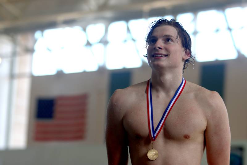 Drew Watson of Cary-Grove co-op poses on the award stand after winning the 100-Yard Backstroke during the Fox Valley Conference Swimming Championships at Woodstock North High School Saturday.
