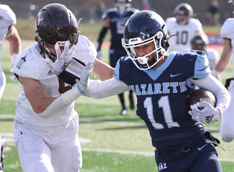 Nazareth's James Penley holds off Joliet Catholic's Zachary Beitler Saturday, Nov. 25, 2023, during their IHSA Class 5A state championship game in Hancock Stadium at Illinois State University in Normal.