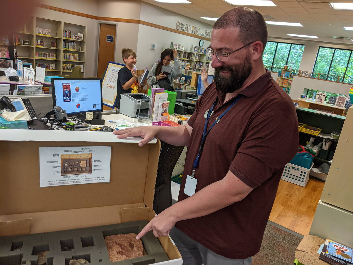 Kevin Egan, the Oswego Library District’s assistant department head of youth services, sorts through dinosaur fossils and other fossils that will be on display at the Oswego campus, 32 W. Jefferson St. in downtown Oswego.
