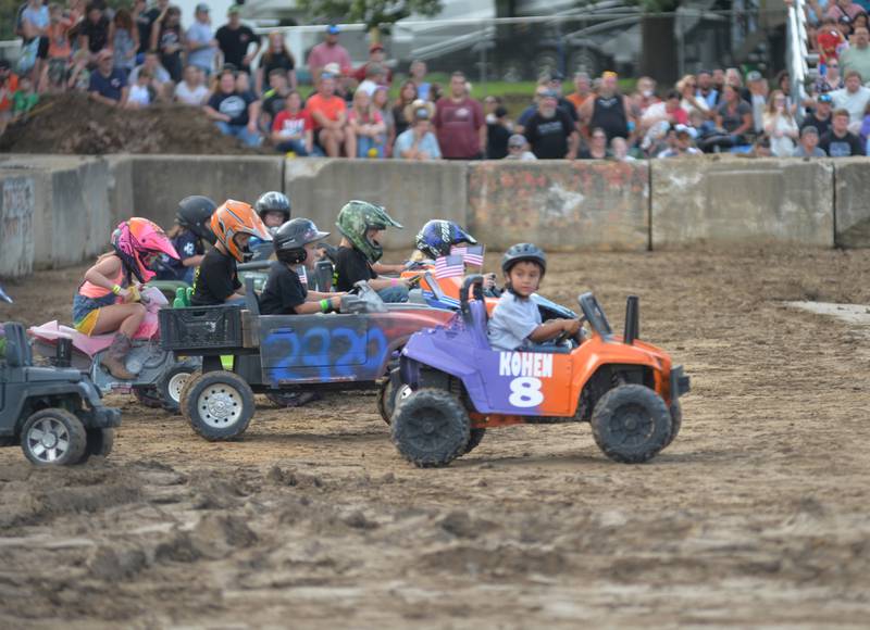 Kaden Blasdell, 4, of Morrison, looks to his dad as he drives his battery-powered 4-wheeler in the kids race at the Whiteside County Fair's demolition derby on Saturday, Aug. 17, 2024.