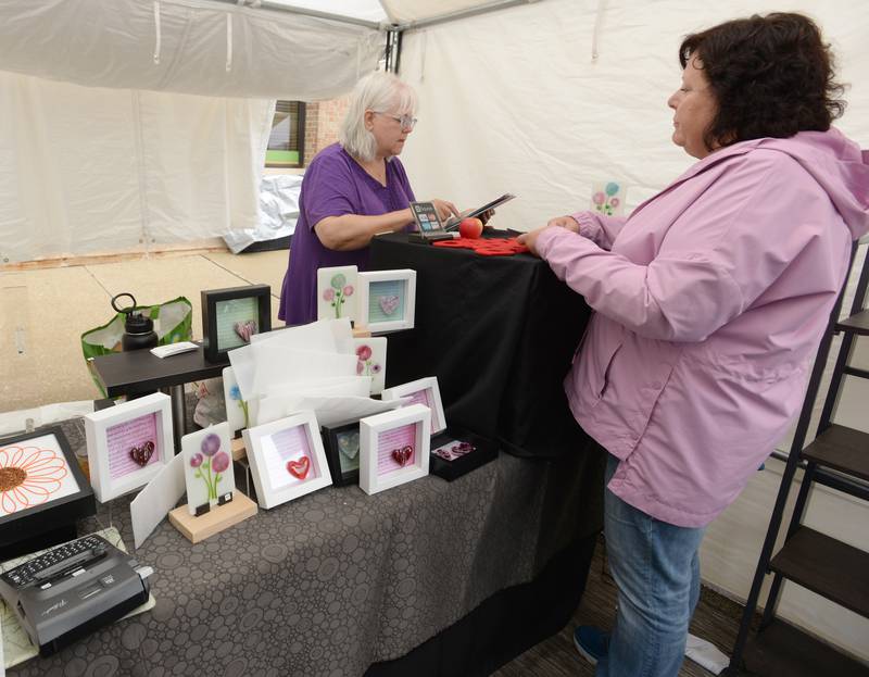 Rita Skarha of Naperville sells one of her art pieces to Kim Fuller of La Grange during the Art Fest held Sunday Sept 11, 2022.