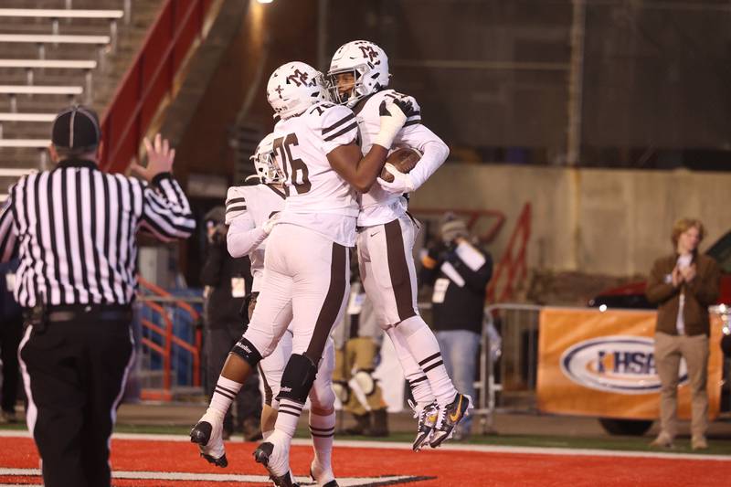 Mt. Carmel’s Lamont Miller, left, celebrates Maurice Densmore’s touchdown against Downers Grove North in the Class 7A championship on Saturday, Nov. 25, 2023 at Hancock Stadium in Normal.
