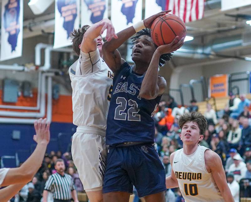 Oswego East's Jehvion Starwood (22) shoots the ball in the post against Neuqua Valley's John Bieber (55) during a hoops for healing basketball tournament game at Oswego High School on Friday, Nov 24, 2023.