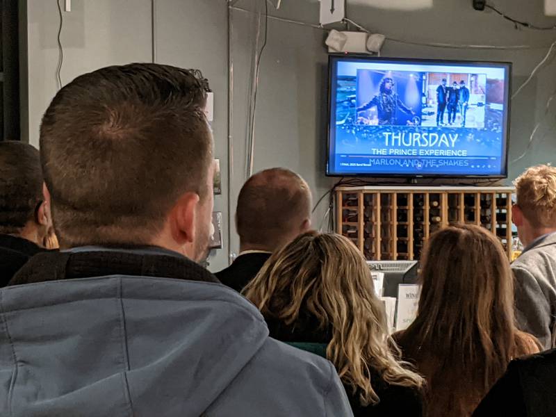 People watch a screen as this year's band lineup is announced Jan. 15 at the Park District’s PrairieFest Partner Preview Night at the Fox Valley Winery in downtown Oswego.