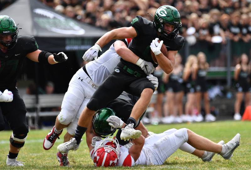 Glenbard West's Rhett Pierce tries to escape two Marist tacklers during a game on Aug. 26, 2023 at Glenbard West High School in Glen Ellyn.
