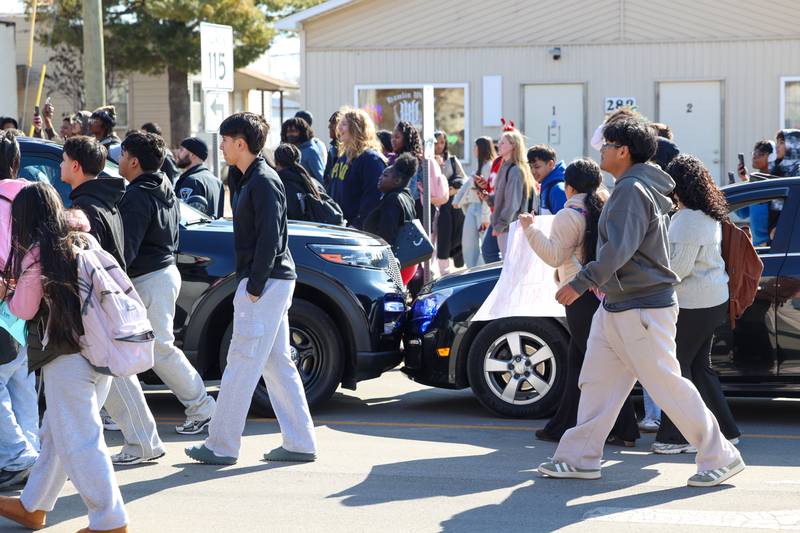 Kankakee High School students pass by the area where a student-driven car collided with a parked Kankakee Police squad as they participated in a walkout in protest of national immigration policies and Immigration and Customs Enforcement actions on Friday, Feb. 13, 2026.