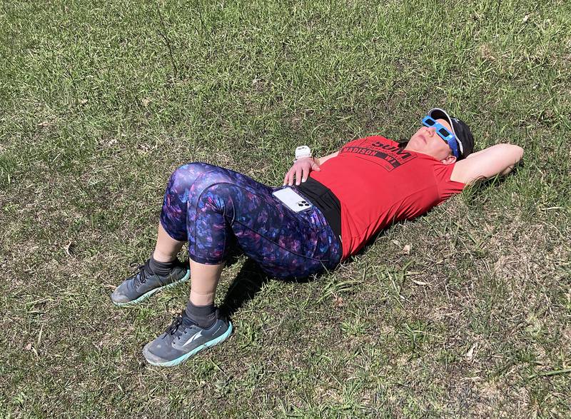 Brandi Henry takes a break from her daily run to watch the partial eclipse Monday, April 8, 2024, at the Crystal Lake Park District's Nature Center.