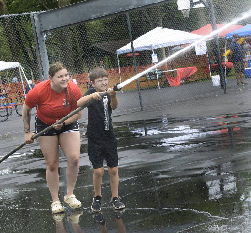 Joseph Sment gets some help from Maria Pawlak of the Spring Valley Fire Dept. Saturday during the water fights competitions as part of Spring Valley’s Summerfest.