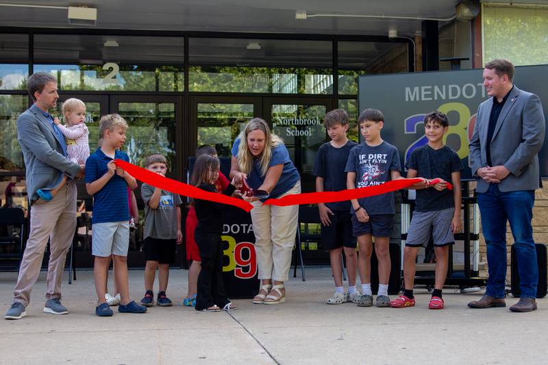 Mendota Elementary staff and children, and State Rep. Bradley Fritts, R-Dixon, (right) hold a ceremonial ribbon to celebrate the school district's solar update on Thursday, July 18, 2024, at Northbrook Elementary School.