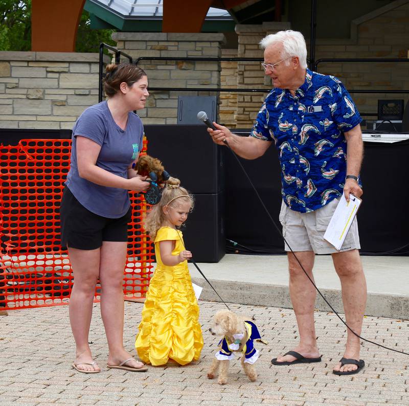 Craig Foltos (of Foltos Tonsorial Parlor) interviews Giana Ayres, as her 3-year-old daughter Amalia Ayers and dog Calvin enter the pet competition as Beauty and the Beast at the annual Batavia Windmill City Festival on Saturday, July 12, 2025.
