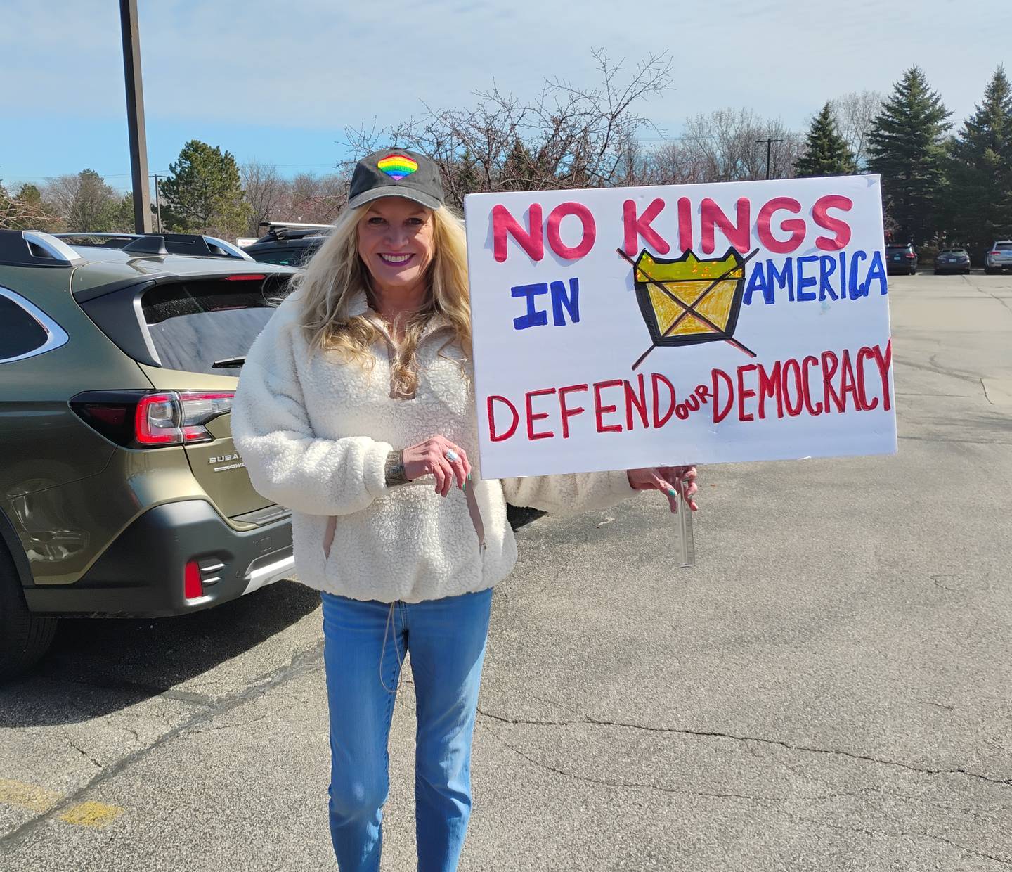 Gretchen Goldsworthy of Geneva carries her sign to the No Kings rally at Silver Glen and Randall roads in South Elgin on Saturday, March 28.