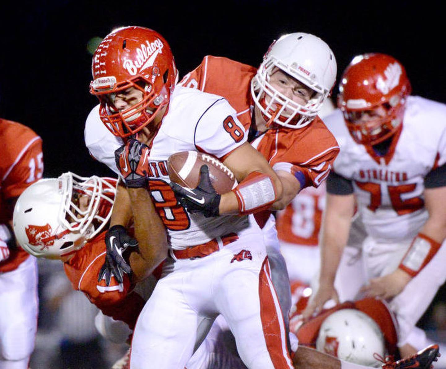 Streator running back Nick Harcar tries to break free from Ottawa tacklers Devon Jones (left) and Alex Hinrichs at King Field during the last contested Route 23 Rivalry game in 2013.