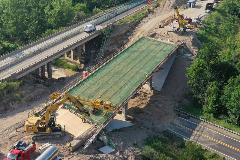 An aerial view of crews working on the Interstate 180 bridge crossing over the Tiskilwa Bottom Road on Tuesday, July 8, 2025 near Tiskilwa. The Illinois Department of Transportation continues to work on the 180 bridges over Bureau Creek and Tiskilwa Bottom Road.  The I-180 work zone is a mile south of the Route 26 interchange. Both the south and northbound bridges are being replaced. Girders have been installed on the bridge. Tiskilwa Bottom Road remains closed under I-180 during the project and traffic should follow the posted detour signs. The  24.2 million  project is scheduled to be completed by the end of 2026.