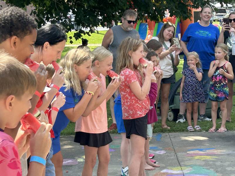 Kids chow down on their slice of watermelon at the watermelon-eating contest at Sauerkraut Days in Forreston on Saturday, Aug. 2, 2025.