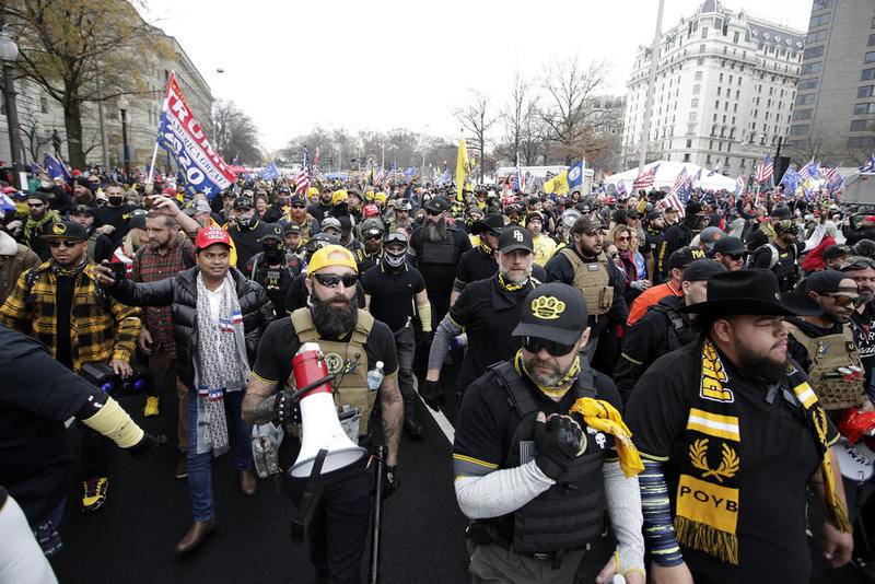 Supporters of President Donald Trump who are wearing attire associated with the Proud Boys attend a rally at Freedom Plaza, Saturday, Dec. 12, 2020, in Washington. (AP Photo/Luis M. Alvarez)