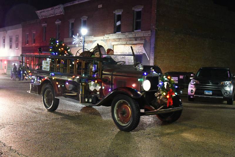 Mt. Morris Fire Chief Rob Hough, IV and his wife, Lynette, ride in the fire department's antique fire truck during the lighted parade on Saturday, Dec. 2, 2023.