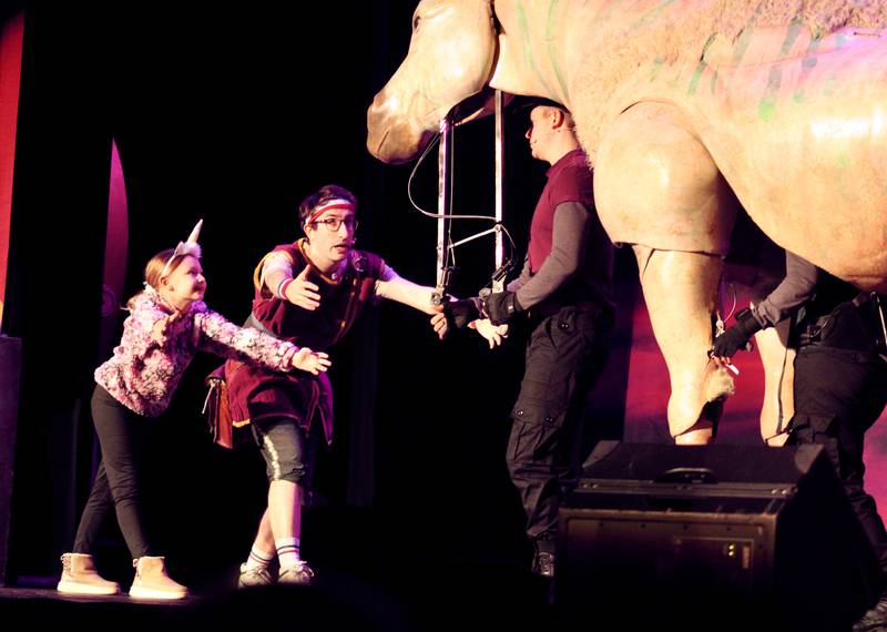 Dave the Hero Trainer and a member of the audience bow to unicorn puppet to gain its trust during the first of two performances of "Dragons and Mythical Beasts" on Saturday, Feb. 11, 2023, at Dixon Theatre.