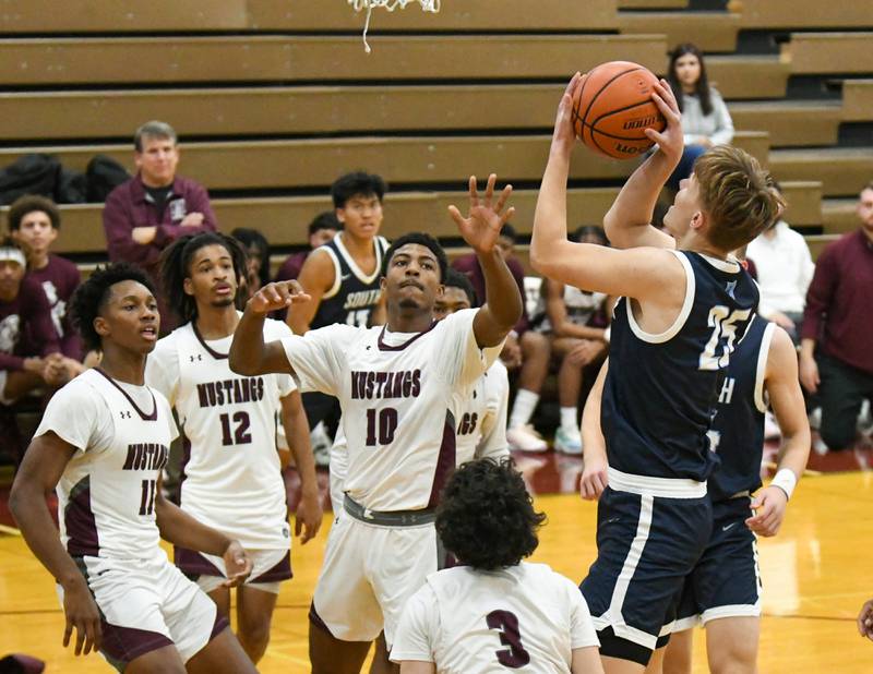 Downers Grove South's Daniel Sveiteris (25) takes a shot in the first quarter while being defended by Morton East's Michael Barnes jr. (10) during the first quarter on Saturday Dec. 9, 2023, held at Morton East High School.