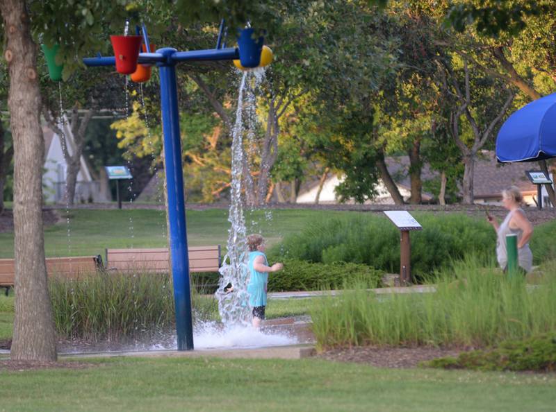A kid cools off at the Splash Park next to the Oregon Park District's Concert in the Park on Tuesday, July 15, 2025 at Oregon Park West.