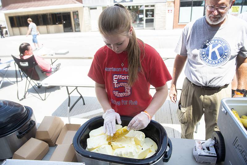 BayLeigh Brewer, 17, slathers on the butter Saturday, July 30, 2022 during Morrison’s Shuckfest. Brewer was volunteering for the fest as part of the Morrison High School volleyball team.