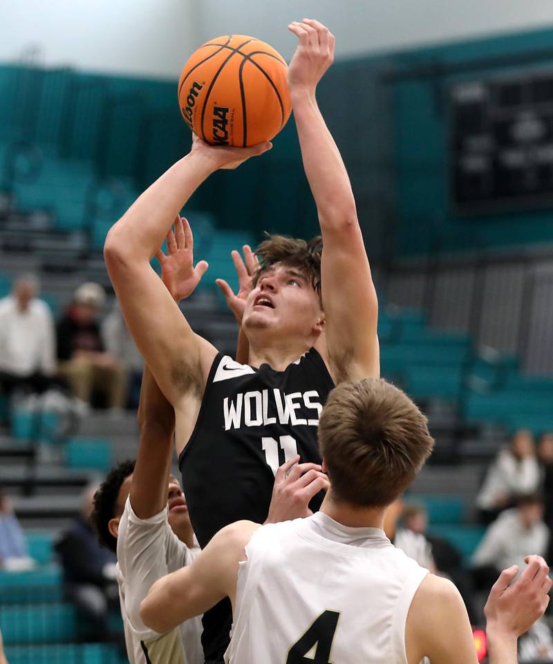 Prairie Ridge's Elijah Loeding shoots the ball between Grayslake North's Will Foley (left) and Jared Van Donselaar (right) during the 2025 Hoops for Healing tournament basketball game on Wednesday, Nov. 26, 2025, at Woodstock North High School.