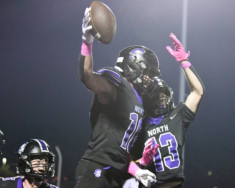Downers Grove North's Oliver Thulin, left, celebrates with teammate Joey Serpico (13) after Oliver scored a touchdown during the game on Friday Oct. 10, 2025, while taking on York High School held at Downers Grove North High School.