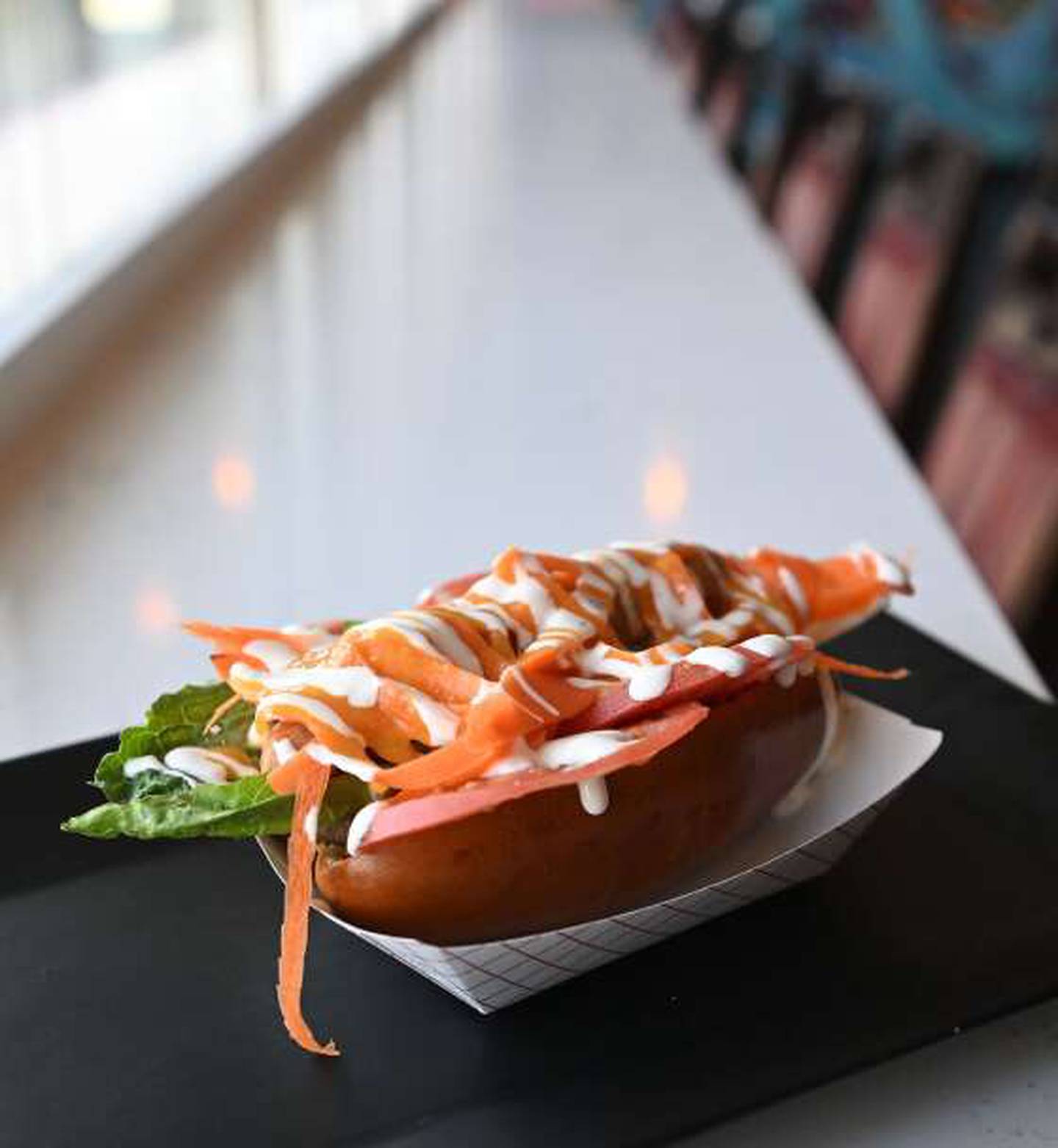 The Remember Halloween dog from Legit Dogs & Ice in South Elgin features a jumbo chicken hot dog topped with tomato, lettuce, carrots, bacon, ranch dressing and homemade Buffalo sauce.