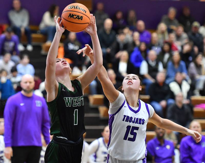 Glenbard West’s Nina Hendricksen (1) puts the ball up as Downers Grove North’s Adysen Fanta (15) defends during a game on January 17, 2026 at Downers Grove North High School in Downers Grove .
