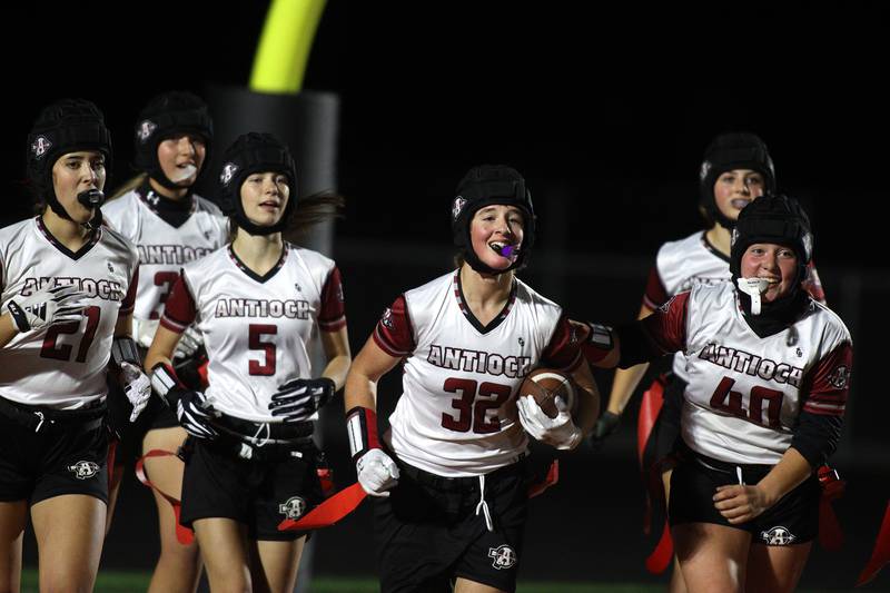 Antioch’s Evelynn Baronello, center, races back after catching a late touchdown against McHenry in IHSA Regional Title Game action flag football at McHenry High School in McHenry on Thursday, Oct. 10, 2024.