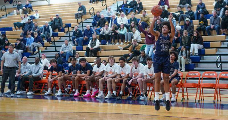 Oswego East's Drey Wisdom (12) shoots a three pointer against Neuqua Valley during a hoops for healing basketball tournament game at Oswego High School on Friday, Nov 24, 2023.
