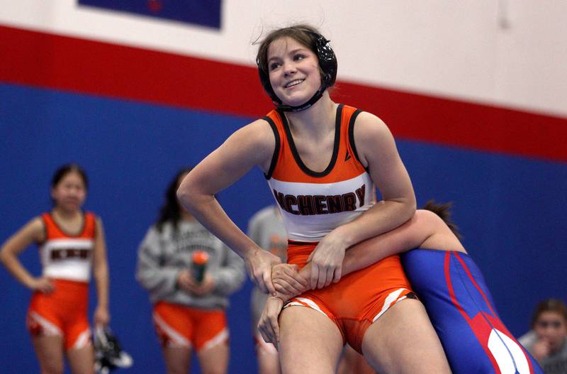 McHenry’s Mackensie Hendricks, front, battles Dundee-Crown’s  Ruby Gavina in a 130-pound bout in girls varsity wrestling at Carpentersville Thursday night.