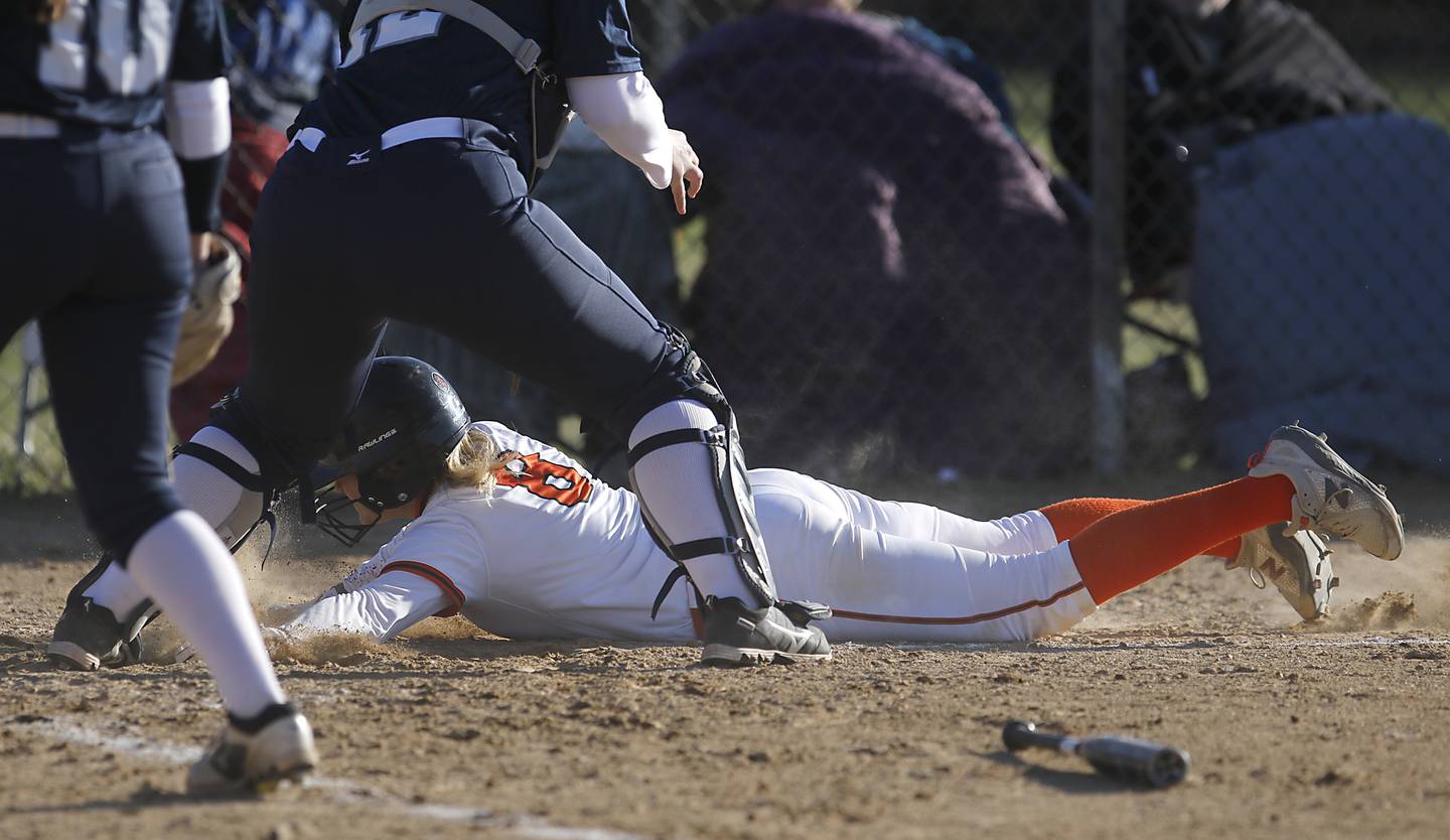 Crystal Lake Central’s Giada Motto dives into home to score a run during a Fox Valley Conference softball game against Cary-Grove Thursday, April 6, 2023, at Crystal Lake Central High School.