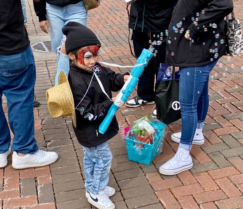 Giovanni Vargas, 4, plays with a bubble gun toy on Sunday, May 4, 2025, in the Frank Van Buer Plaza in downtown DeKalb for the city's annual Cinco de Mayo Celebration.