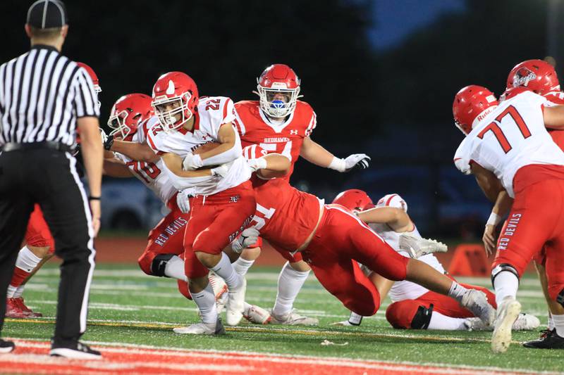 Hinsdale Central's Kellen Tran (22) fights for extra yarkds during football game between Hinsdale Central at Naperville Central.  August 26, 2022.