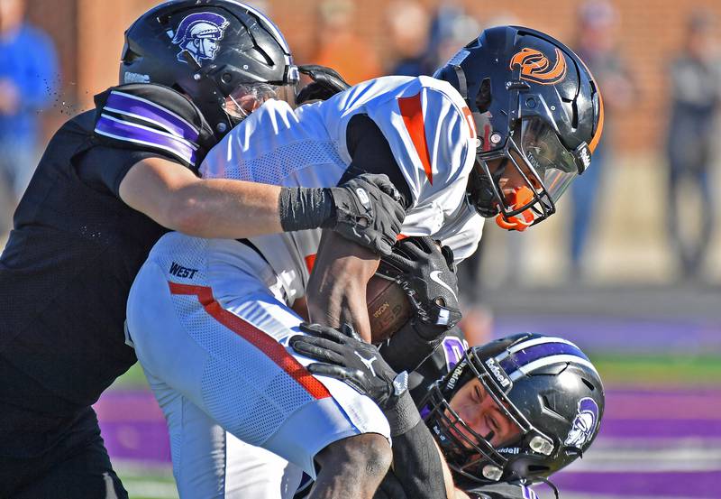 Lincoln-Way West running back Jahan Abubakar is stopped by Downers Grove North’s Luke Williams (left) and Oliver Thulin during a Class 7A quarterfinal game on November 15, 2025 at Downers Grove North High School in Downers Grove .