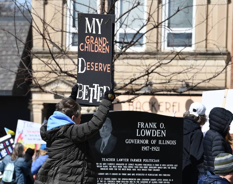 A demonstrator holds a sign at the No Kings rally on Saturday, March 28, 2026, in downtown Oregon, Illinois.