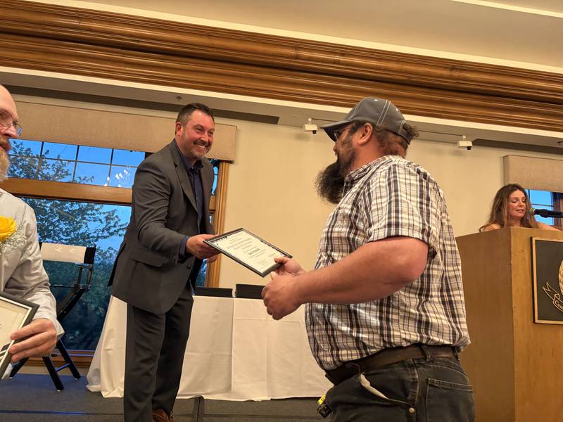 Assistant Regional Superintendent of Schools Chris Zielinski, left, gives noncertified support personnel nominee Jim Schmidt a certificate at the McHenry County Educator of the Year ceremony in Lake in the Hills, Saturday, May 9, 2026.