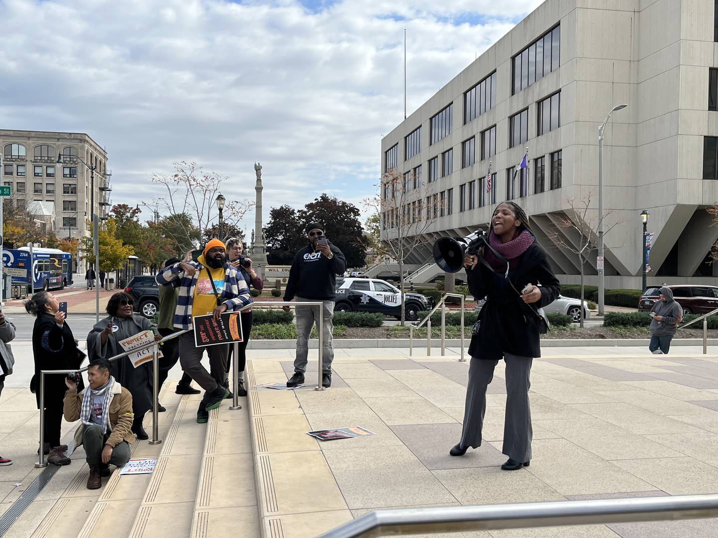 Briana Payton, member of the Illinois Network for Pretrial Justice, holds a megaphone while speaking to a group of protestors gathered in downtown Joliet near the Will County Courthouse on Thursday, Oct. 20, 2022, in support of the SAFE-T Act.