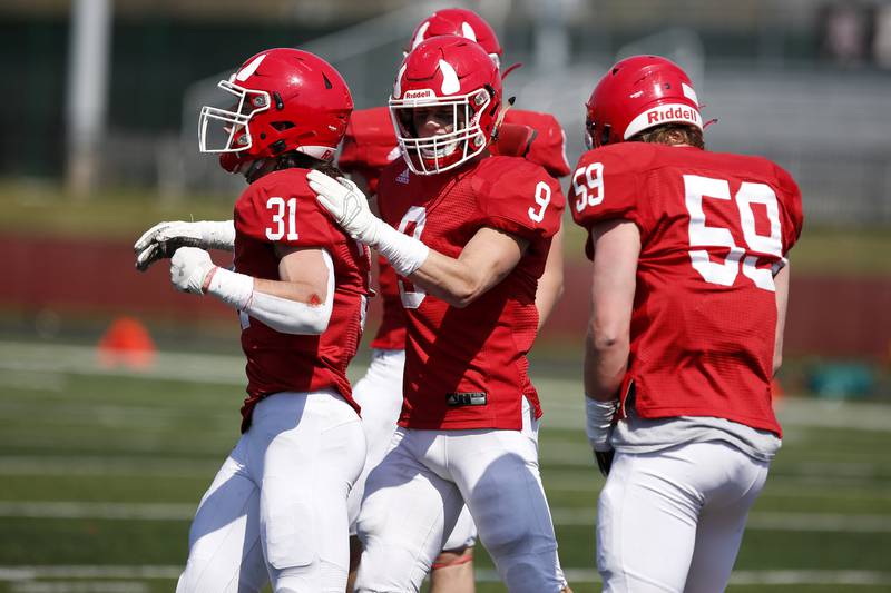 Hinsdale Central’s Jack Costello (from left), JT Pyle, and Alex Meyers celebrate a play during their football game against York at Hinsdale Central High School in Hinsdale, Ill., on Saturday, April 3, 2021.