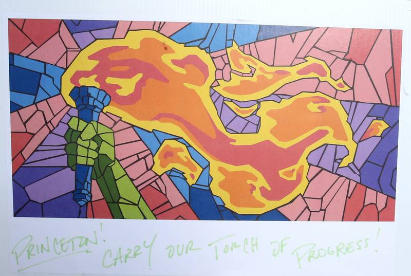 A blueprint of what the finished torch mural looks like that was constructed through the paint a tile for the community mural project with the Princeton Public Arts Commission on Friday, June 20, 2025 downtown Princeton. The new mural will be displayed in the "Prairie Dreams" alleyway next to Fawcetts Pharmacy on South Main Street in Princeton.  “Prairie Dreams” is a living room grouping of mosaic-clad furniture (sofa, table and chairs) set under cloth sails and string lights along The Mary Uthoff Memorial Walkway.