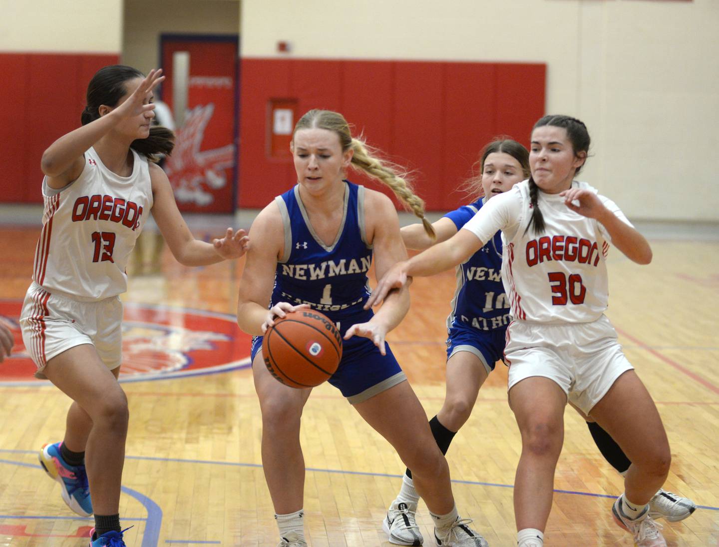 Newman's Jess Johns (center) makes a move to the basket as Oregon's Sarah Eckardt (left) and Mya Engelkes (right) defend during a Monday, Jan. 29, 2024 game at the Blackhawk Center in Oregon.