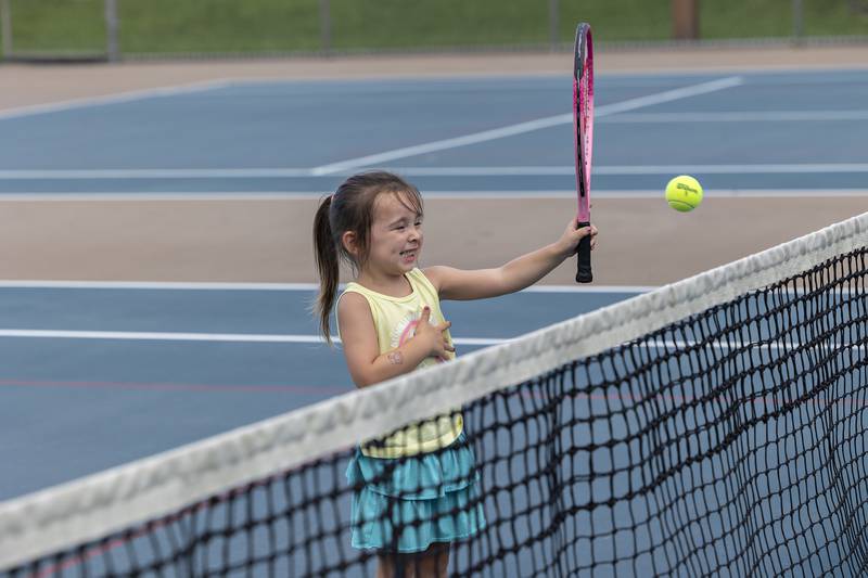 Chloe Kemmerer, 3, practices her tennis skills Friday, July 25, 2025, with help from dad Dylan.