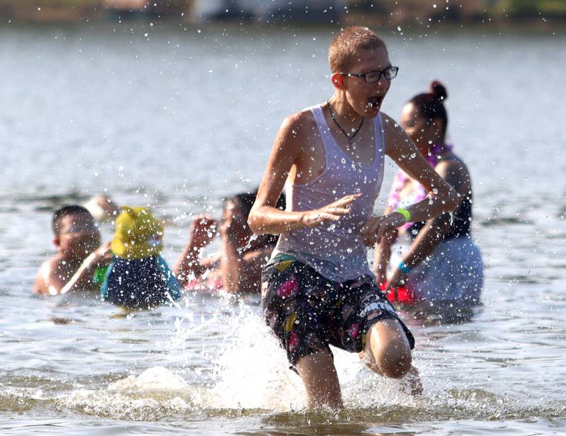 Youngsters splash through the water during the First Day of Summer Beach Party at Indian Trail Beach Wednesday evening in Lake in the Hills.