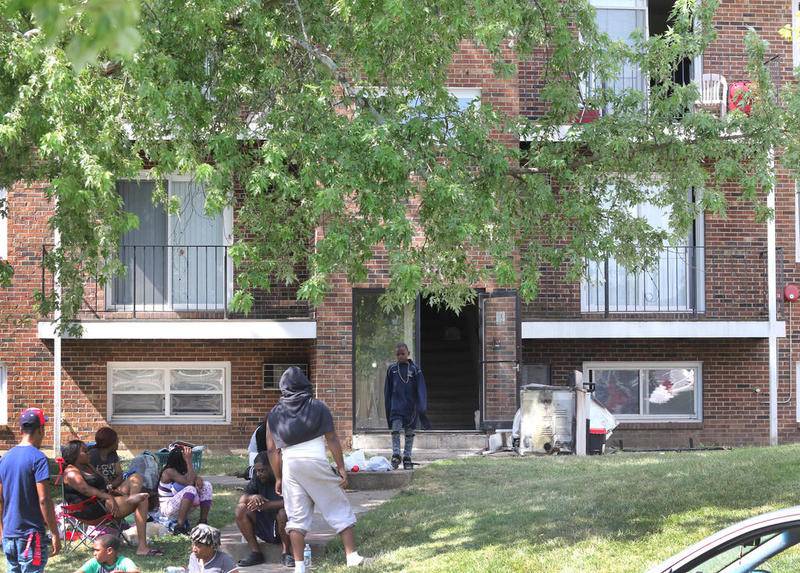 Residents gather last Thursday in front of the apartment complex at 930 Greenbrier Road in DeKalb after a suspicious morning fire at the location. This building is owned by Hunter Properties who also own Ridgebrook Apartments where a fire that occurred Tuesday night is under investigation.