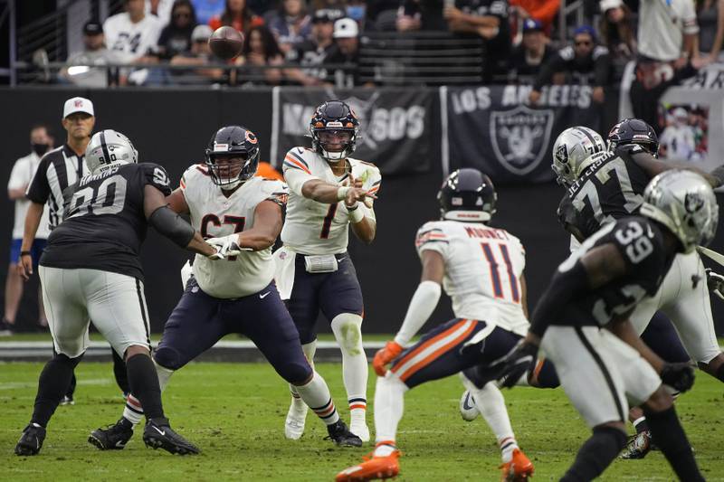 Chicago Bears quarterback Justin Fields (1) throws to wide receiver Darnell Mooney (11) during the second half of an NFL football game against the Las Vegas Raiders, Sunday, Oct. 10, 2021, in Las Vegas.