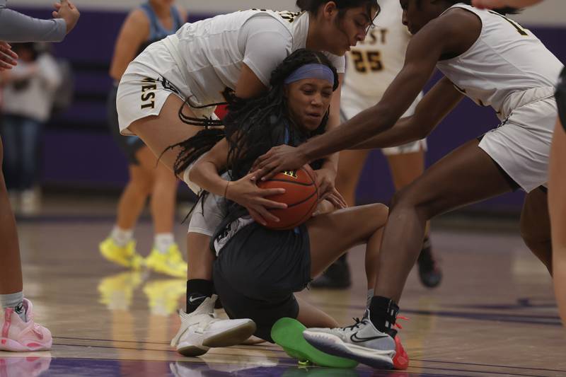 Joliet Catholic’s Layla Pierce secures the loose ball forcing a jump ball against Joliet West in the WJOL Basketball Tournament at Joliet Junior College Event Center on Monday