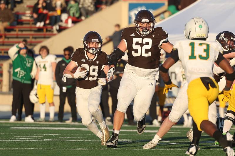 Joliet Catholic’s Keegan Farnaus follows his blocker Brady McKeon on a run against Providence in the Class 5A semifinal on Saturday, Nov. 18, 2023, in Joliet.